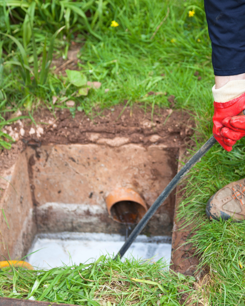 Técnico a realizar limpeza de fossa séptica com equipamento profissiona